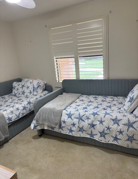 Two beds with starfish-patterned bedding in a bright room with white walls.