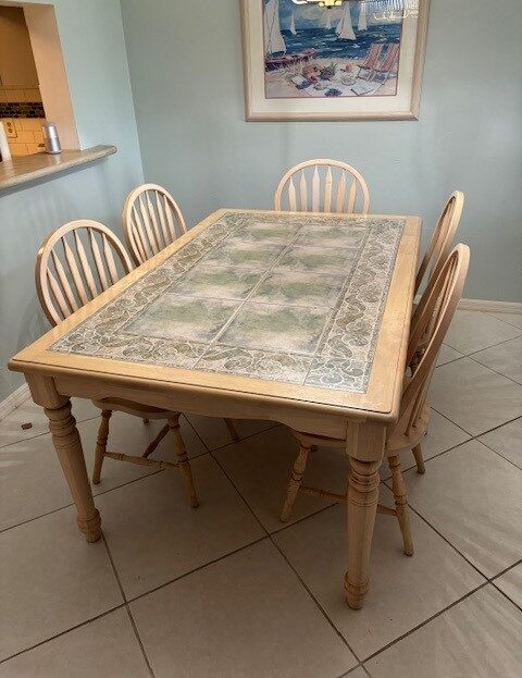 Wooden dining table with six matching chairs in a cozy room.