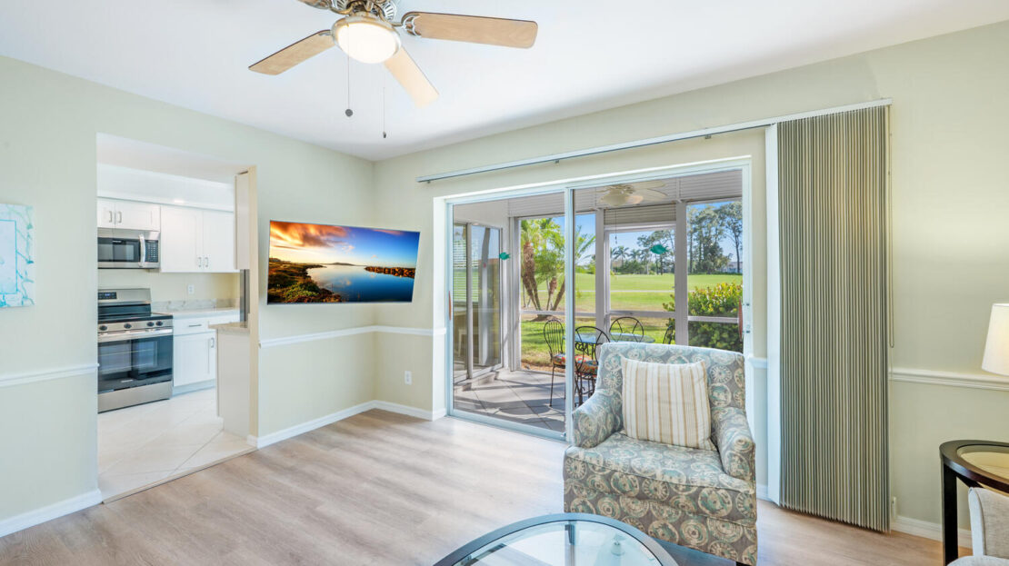 Bright living room with beach-themed decor and sliding glass doors.