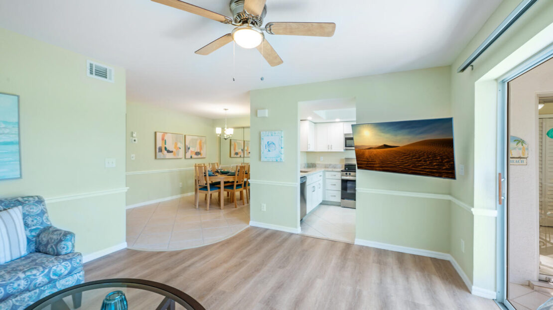 Bright, open kitchen and dining area with modern flooring and ceiling fan.