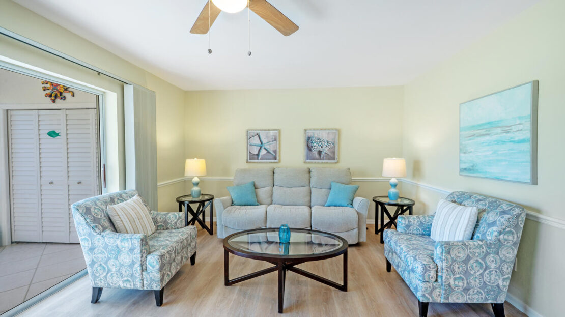Bright living room with light blue furniture and wooden floor.