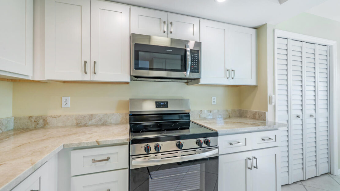 Modern kitchen with stainless steel appliances and white cabinetry.