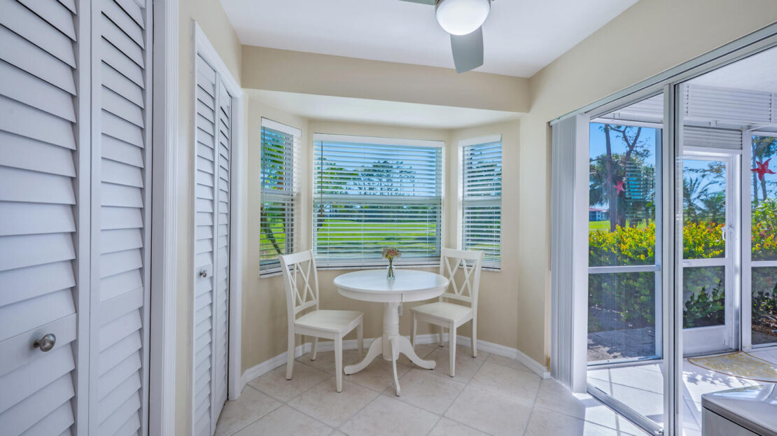 Cozy breakfast nook with lake view and white furniture.