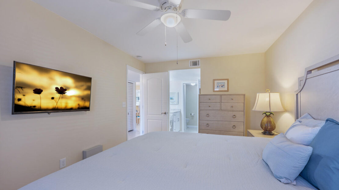 Cozy bedroom with ceiling fan and soft lighting.