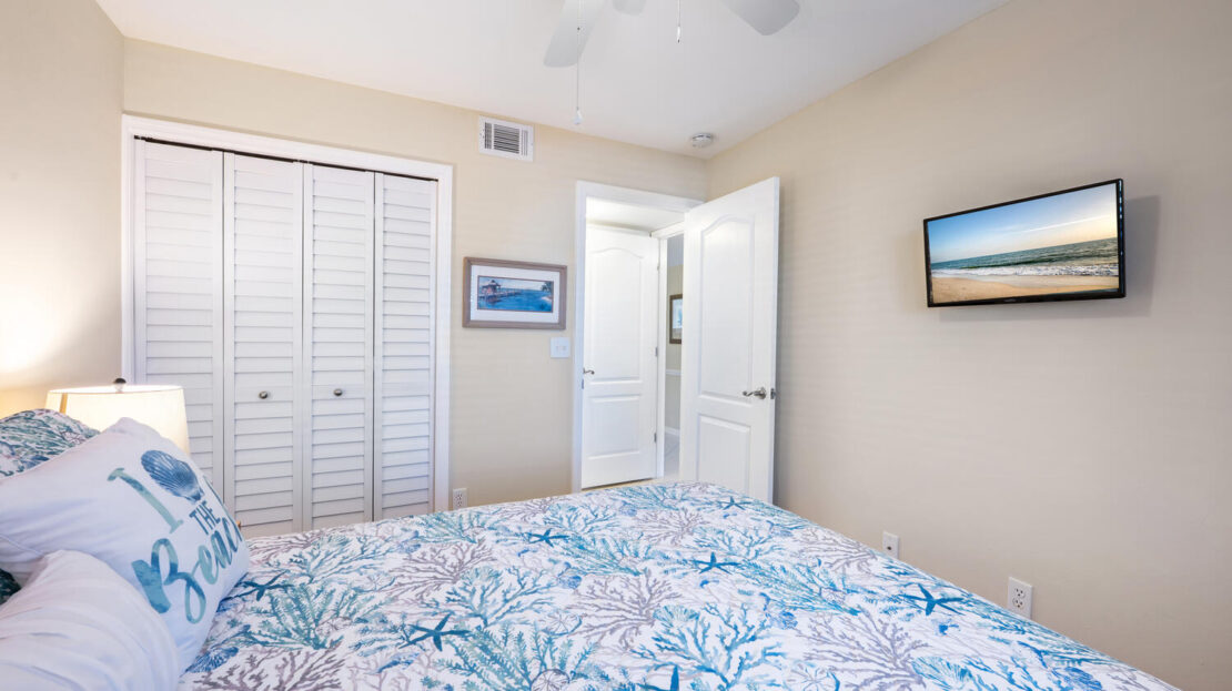 Cozy bedroom with floral bedding and beach-themed decor.