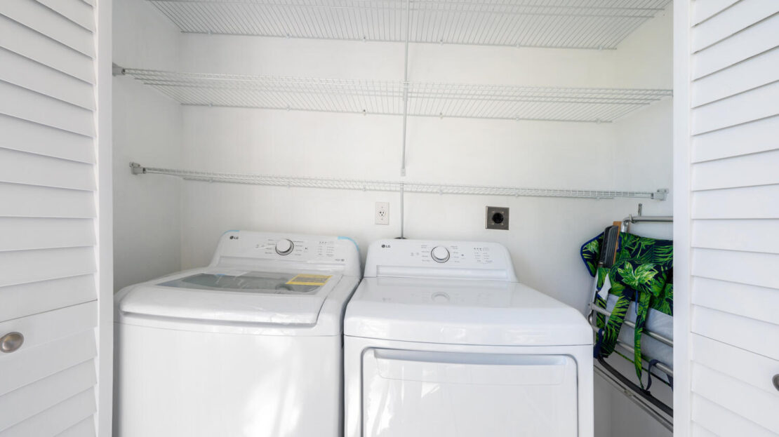 A clean laundry room with a white washing machine and dryer.