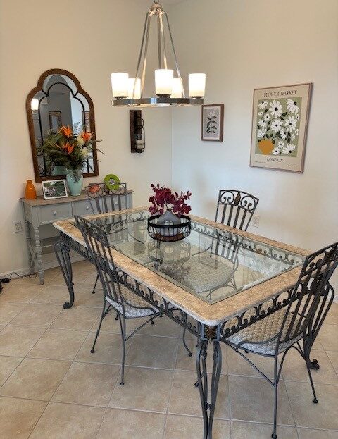Elegant glass dining table with wrought iron chairs in a cozy room.
