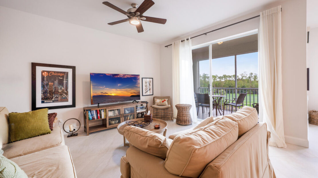 Bright living room with comfortable beige sofa and large glass doors.