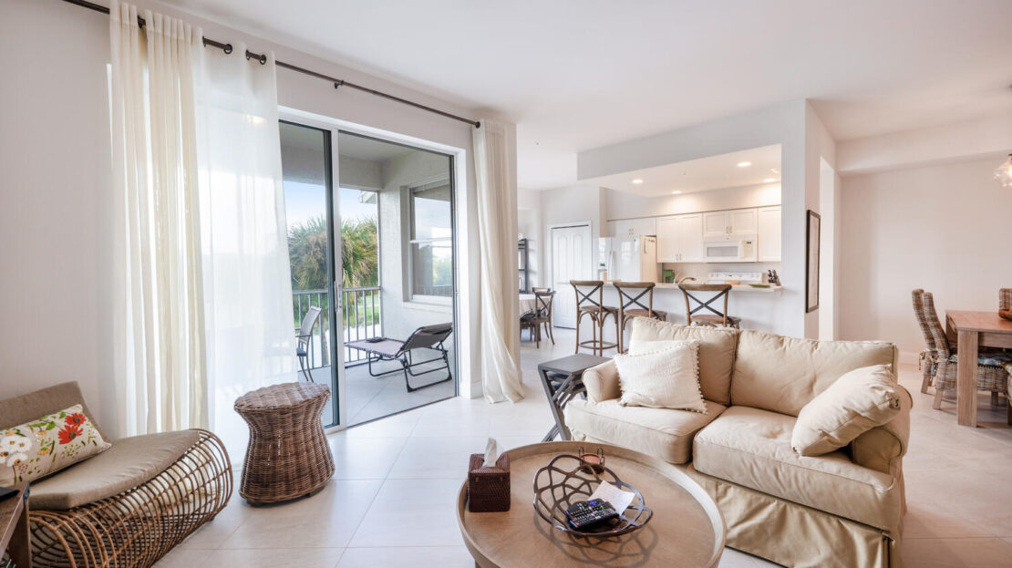 Bright and cozy living room with beige furniture and outdoor view.