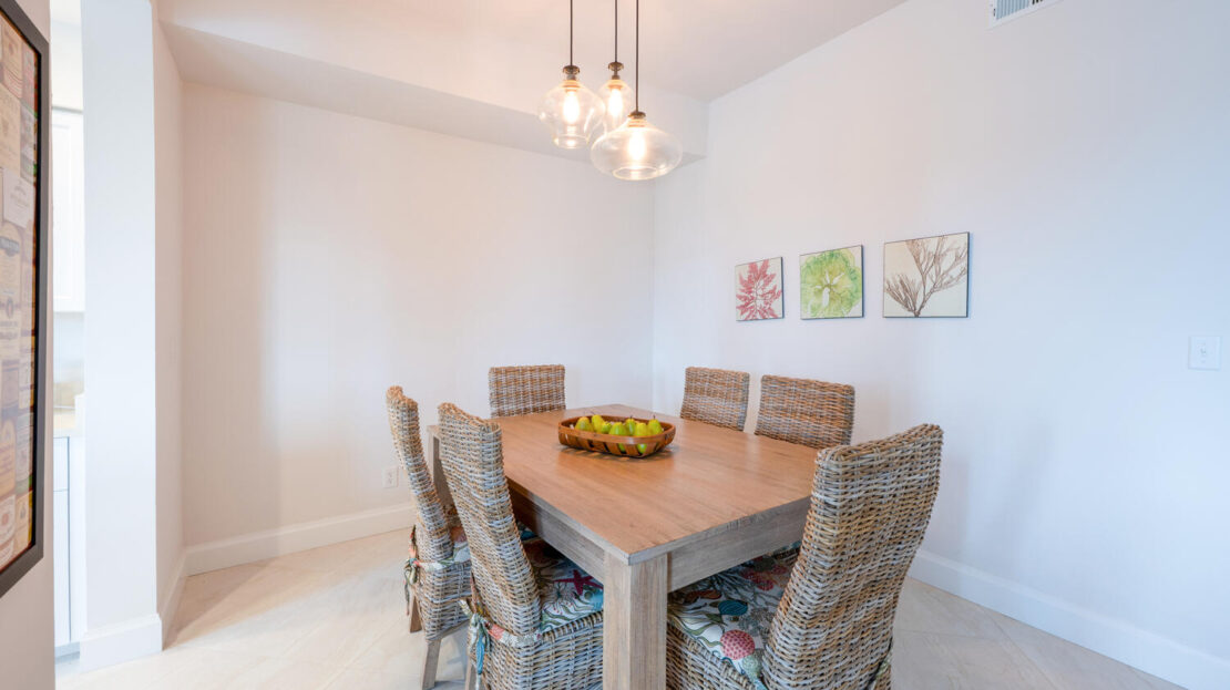 Bright dining room with wicker chairs and a wooden table.