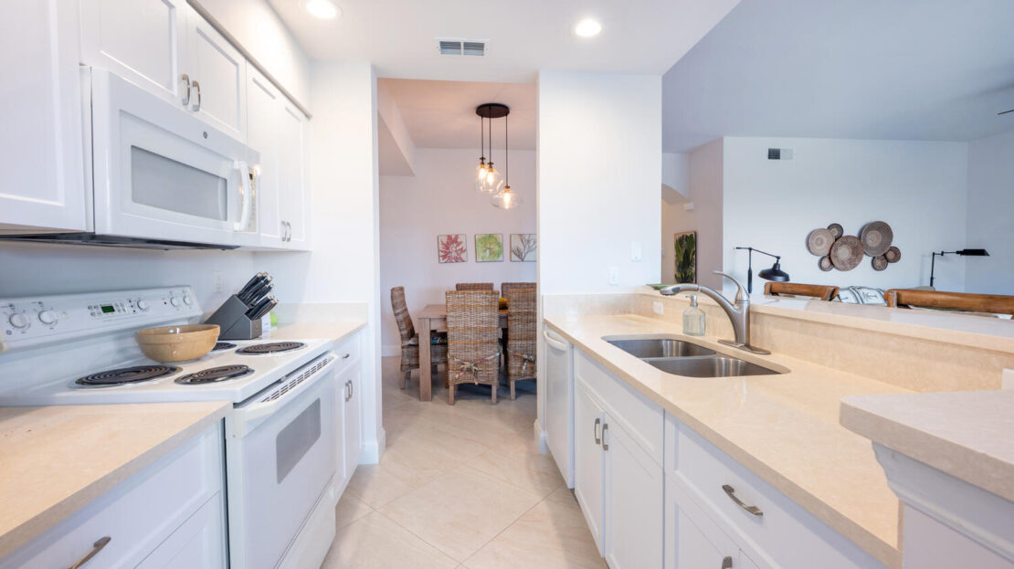 Bright white kitchen with modern appliances and a cozy dining nook.