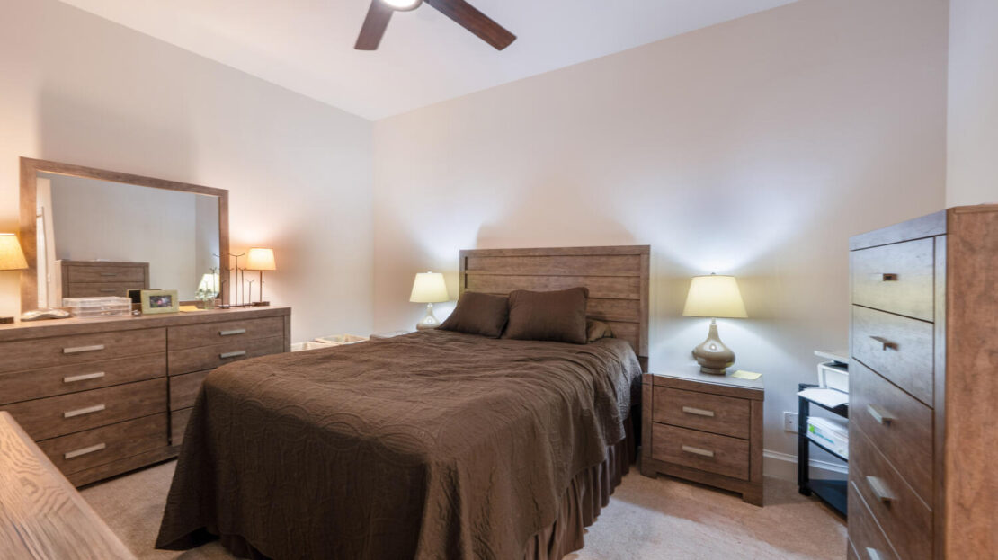 Cozy bedroom with brown bedding and warm lighting.