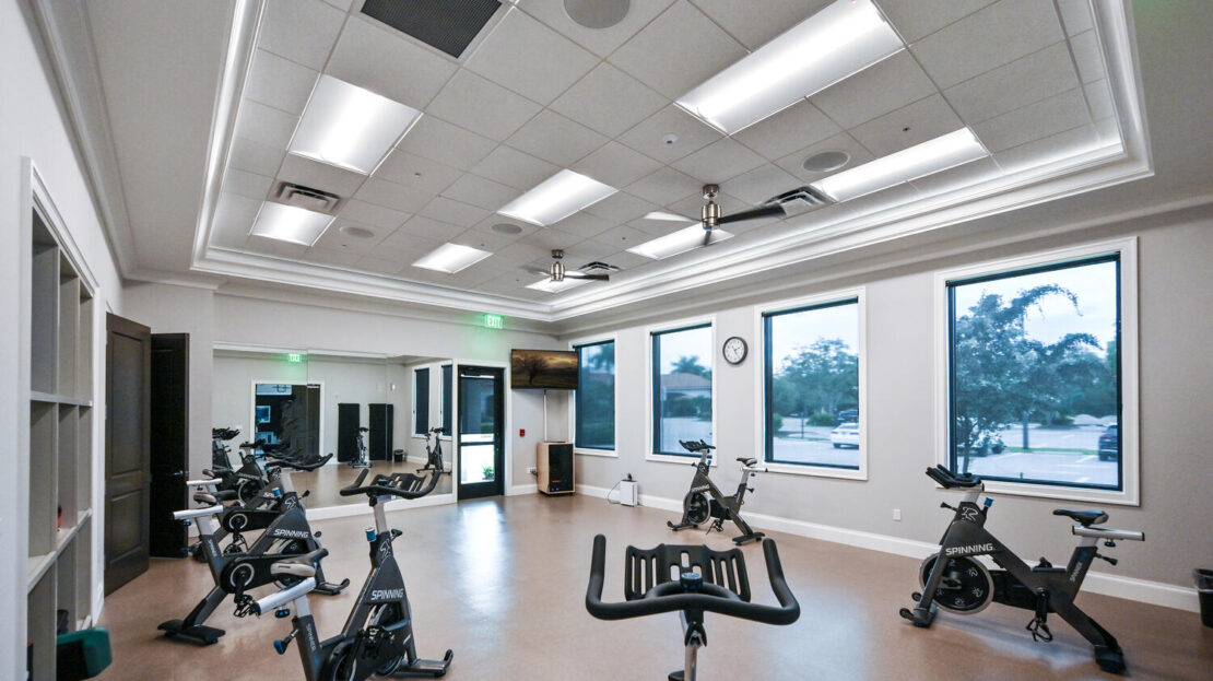 Modern indoor cycling studio with stationary bikes and bright windows.