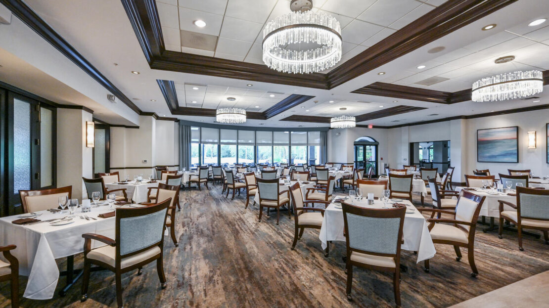 Elegant dining room with chandeliers and wooden floors.