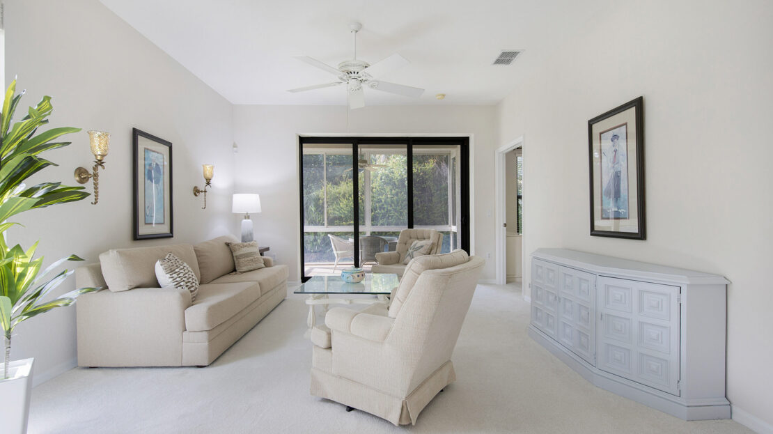 Bright living room with beige furniture and large sliding glass doors.
