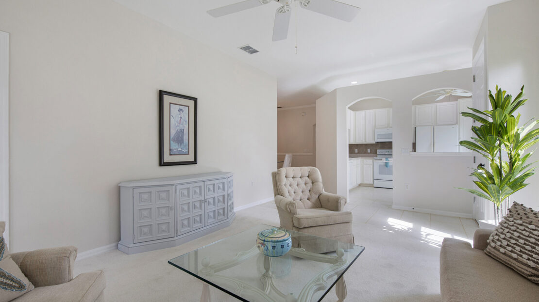 Bright living room with a glass coffee table and comfortable armchair.