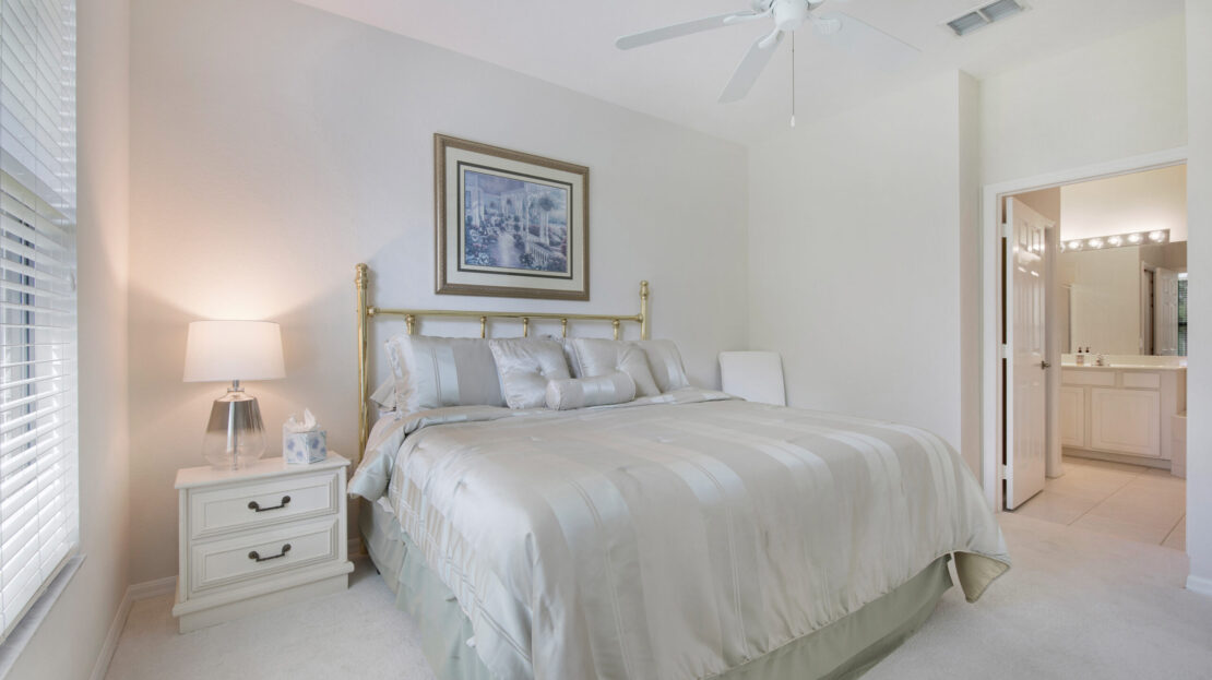 Bright bedroom with a large bed and elegant decor.
