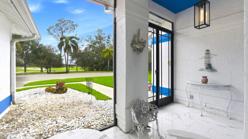 Bright modern patio with white furniture and garden view.