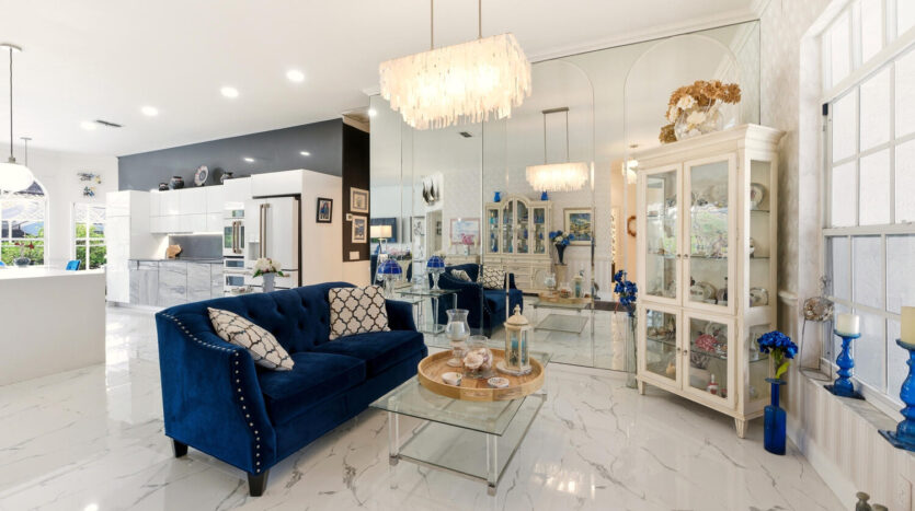 Elegant living room with blue velvet sofa and modern chandelier.