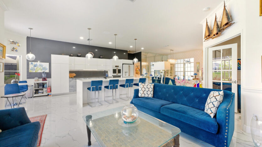 Modern living room with blue sofas and bar stools.