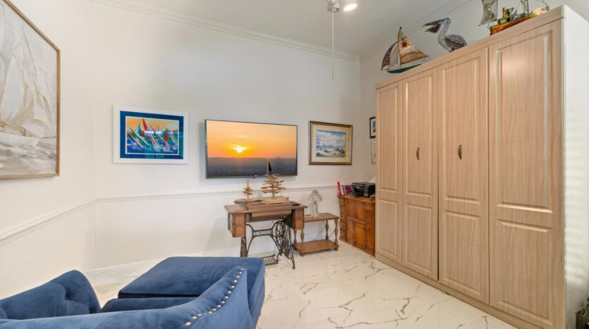 Cozy room with blue couch, wooden furniture, and sunset artwork.