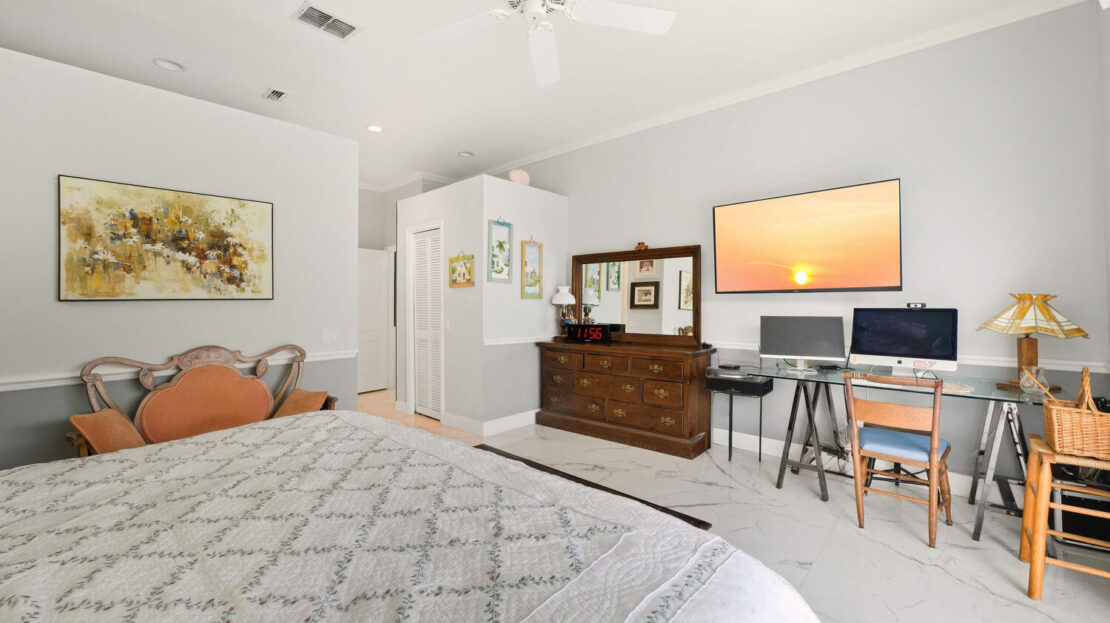 Cozy bedroom with classic wooden furniture and modern workspace.