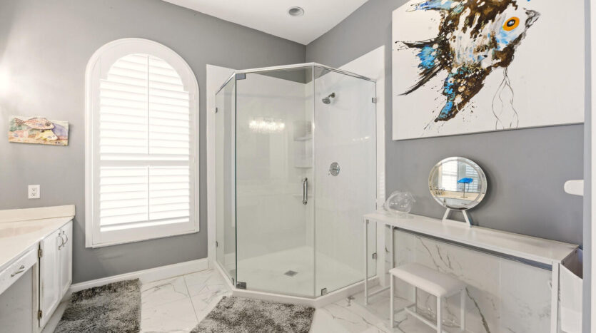 Modern bathroom with glass shower enclosure and elegant decor.