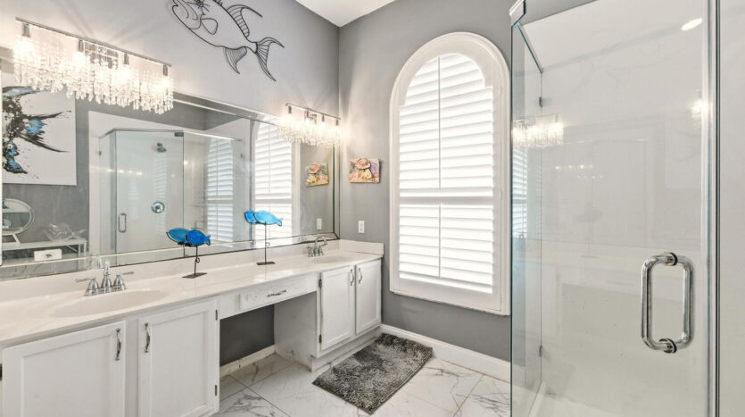 Bright bathroom with marble surfaces and fish wall decor.