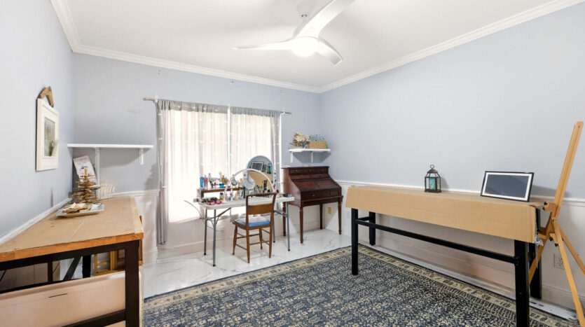 Bright, cozy bedroom with light blue walls and classic wooden furniture.