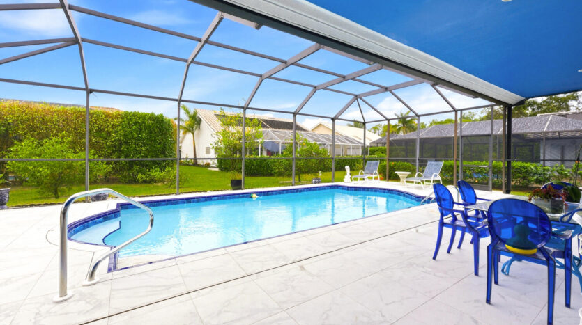 Bright outdoor swimming pool area with clear blue water and white patio.