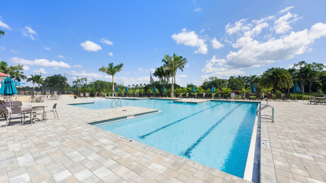 A serene outdoor swimming pool under a sunny blue sky.