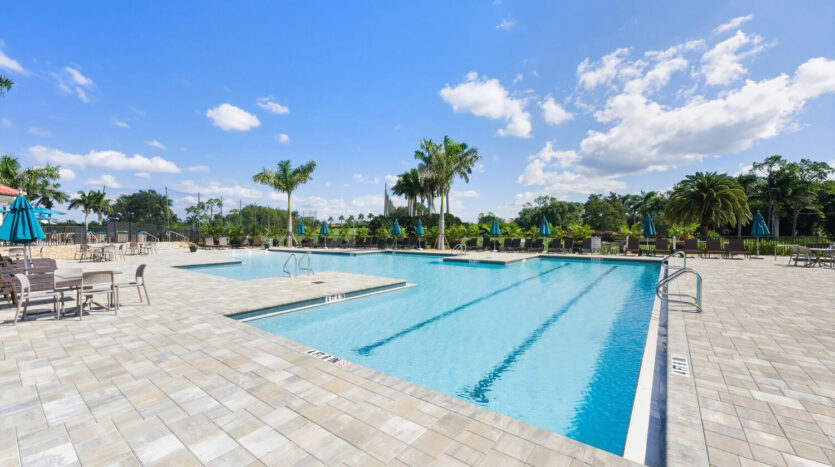 A serene outdoor swimming pool under a sunny blue sky.