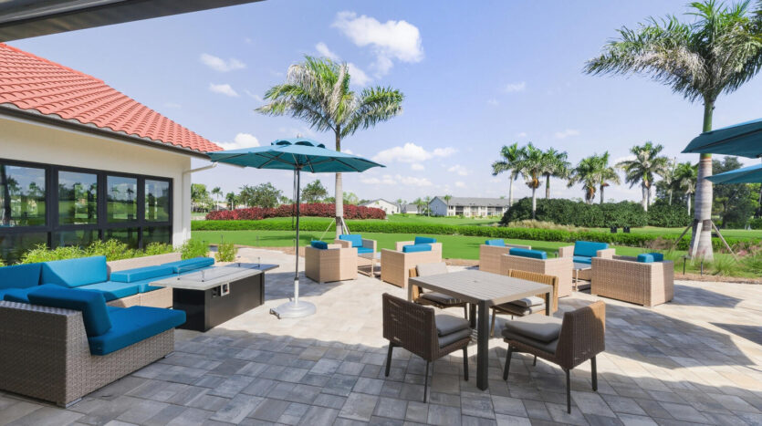 Modern outdoor patio with pool and ocean view under a clear sky.