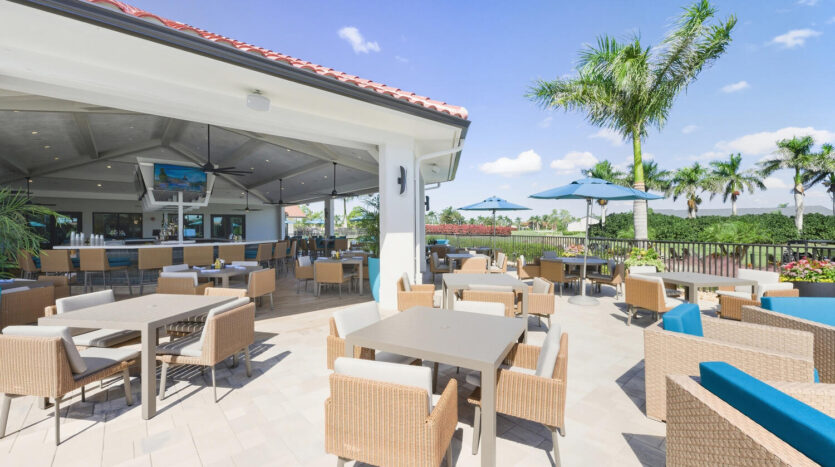 Bright outdoor dining area with wicker chairs and umbrellas under a sunny sky.