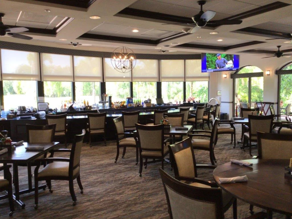 Spacious, well-lit dining area with elegant chairs and large windows.